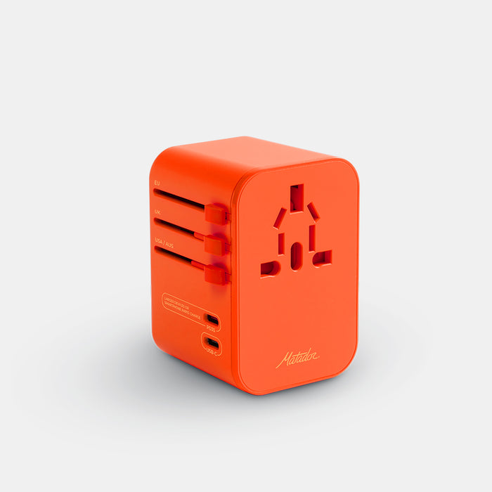 3/4 view of orange travel adapter on light gray background