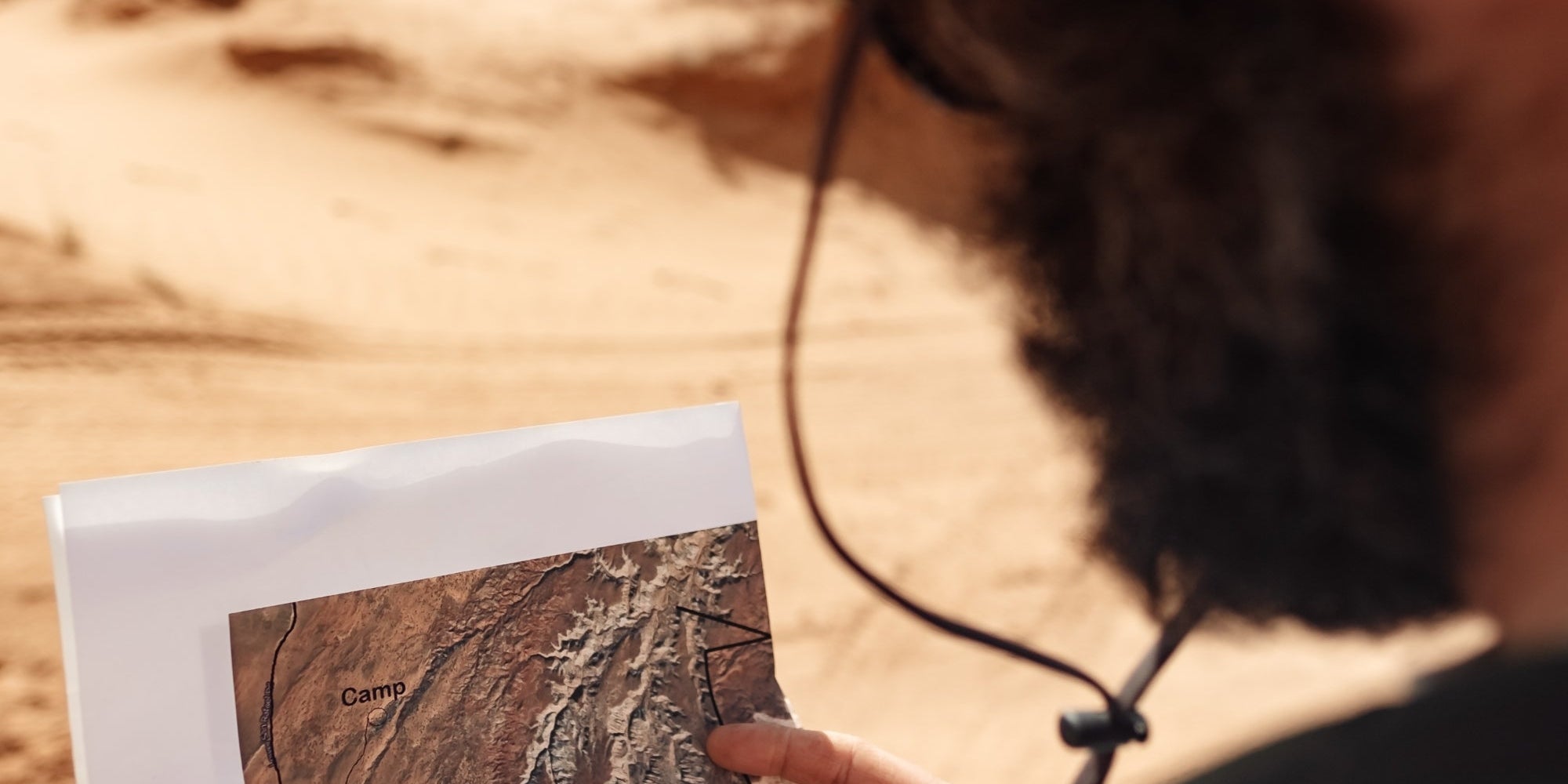 Bearded man outdoors, looking at map