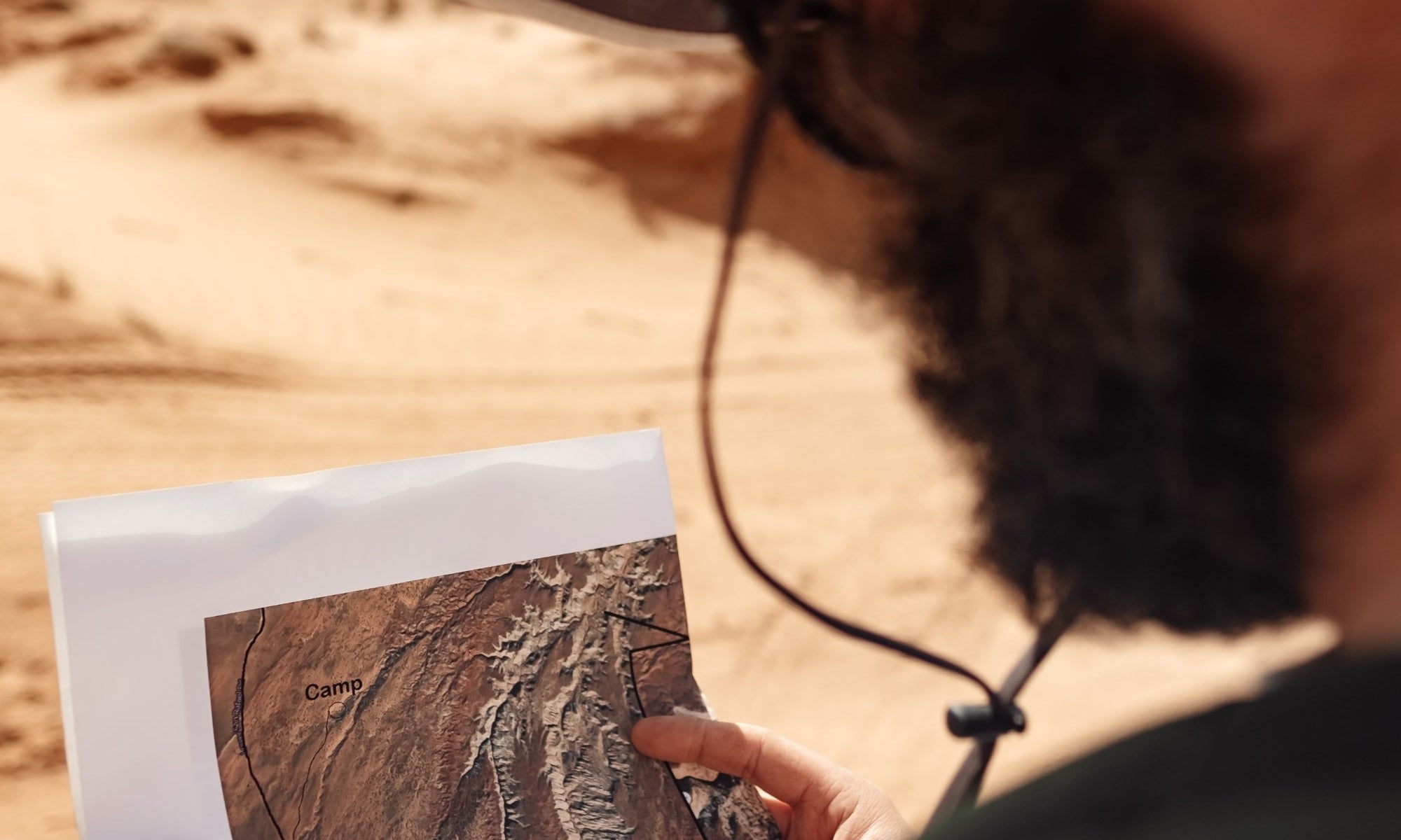 Bearded man outdoors, looking at map