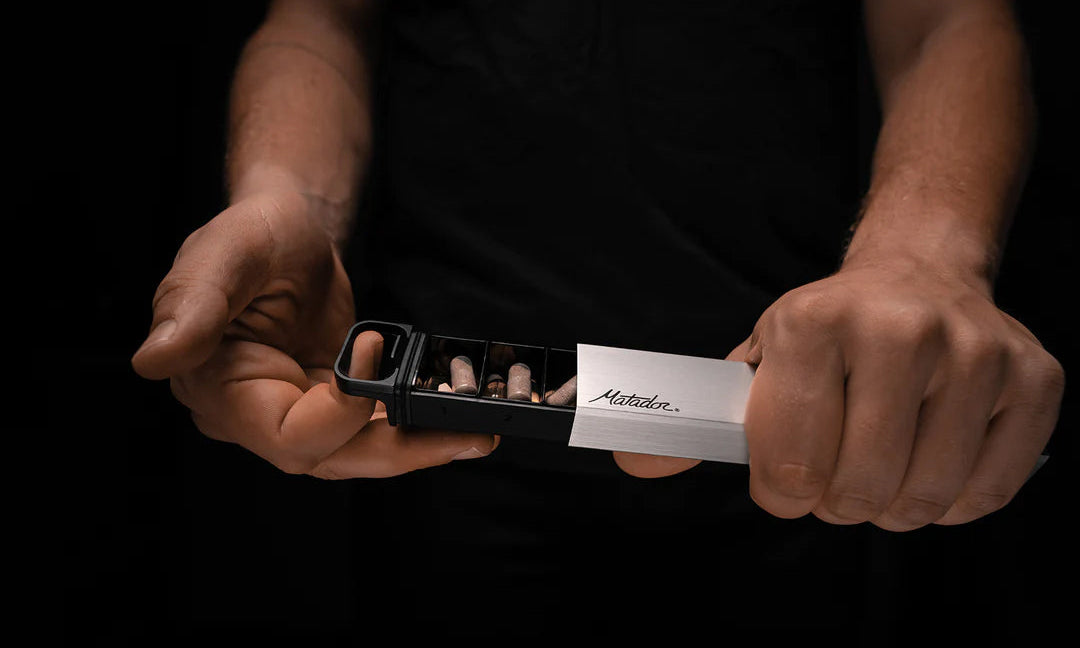 Hands opening pill canister on dark background