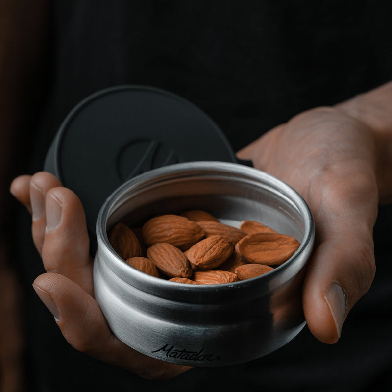 Hand holding canister full of almonds