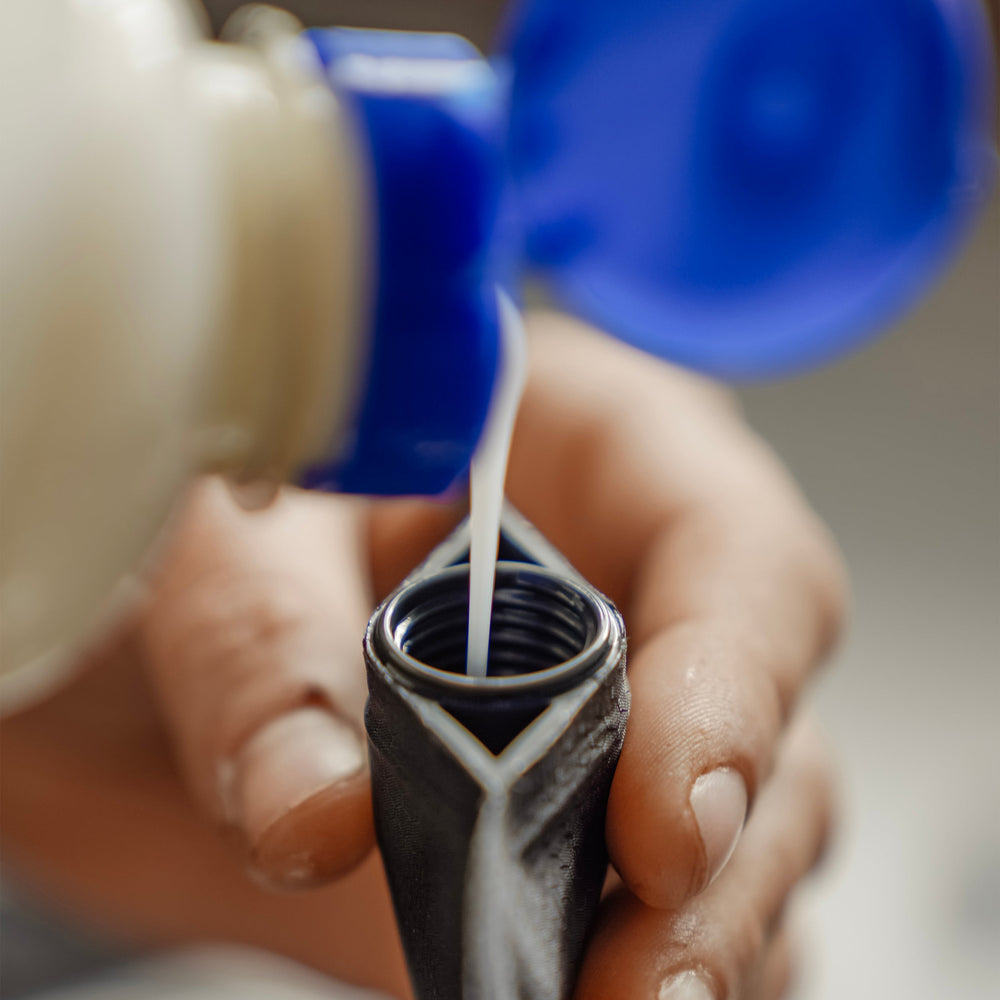 Shampoo being poured into Toiletry Bottle opening