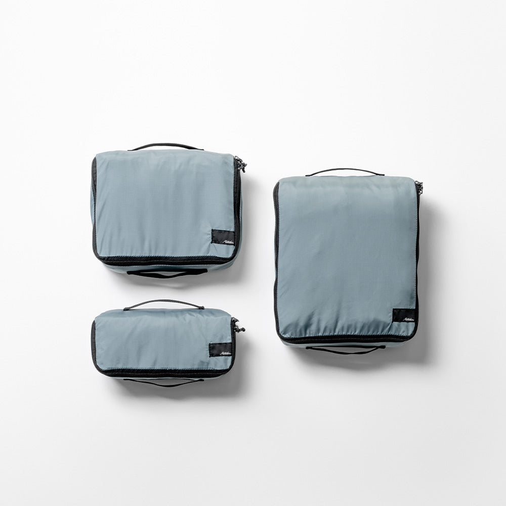 Top view of 3 slate blue packing cubes in small, medium and large against a white background.