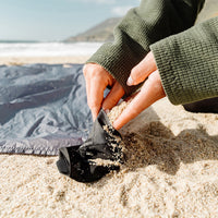 Hands adding sand to Pocket Blanket's sand pocket