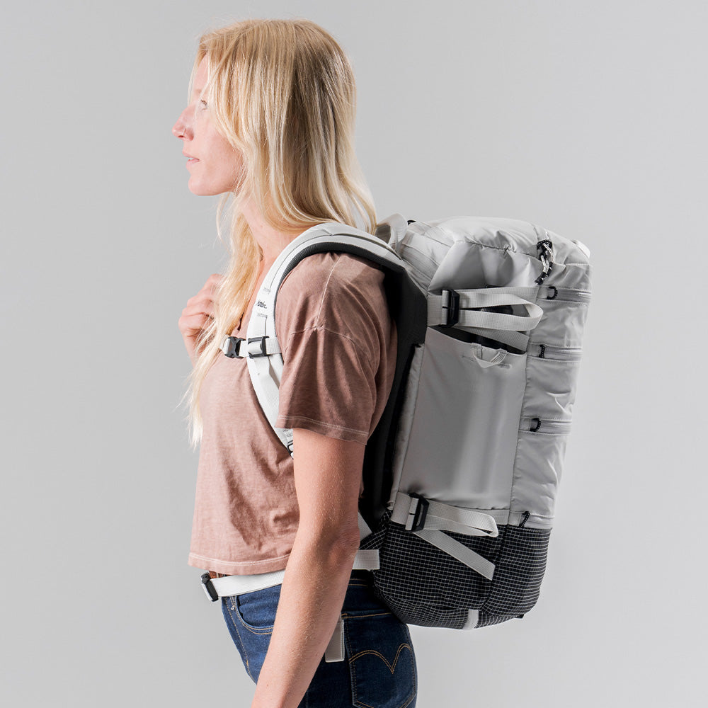 Side view of woman wearing white SEG28 on light gray background