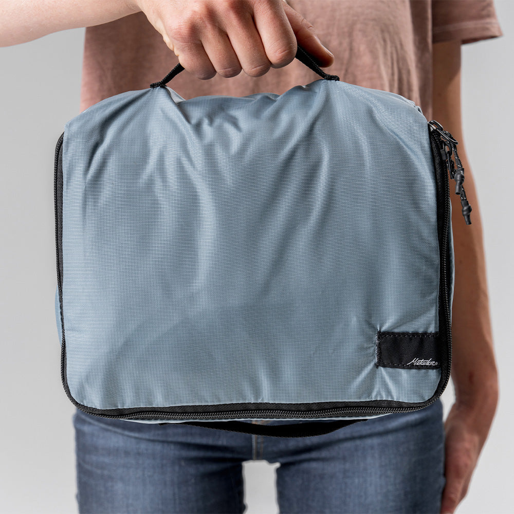 woman holding medium slate packing cube