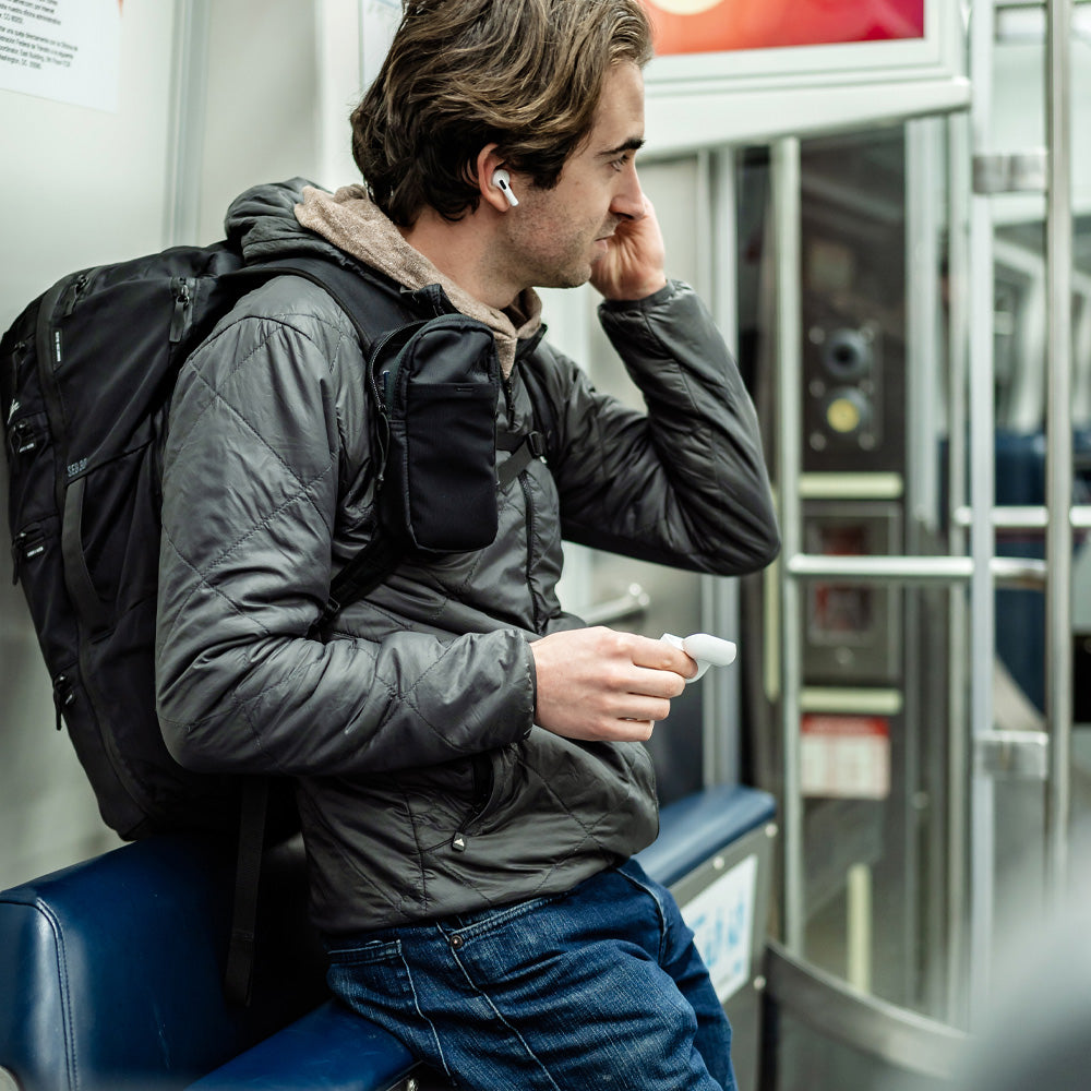 Man on train, pulling headphones out of his Speed Stash