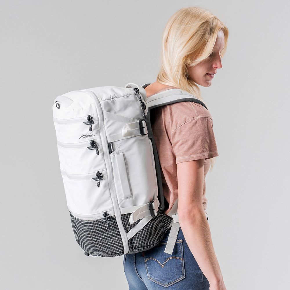 Side view of woman wearing white SEG28 on light gray background