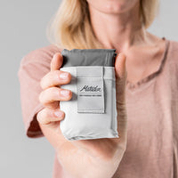 woman holding arctic white Pocket Blanket at camera