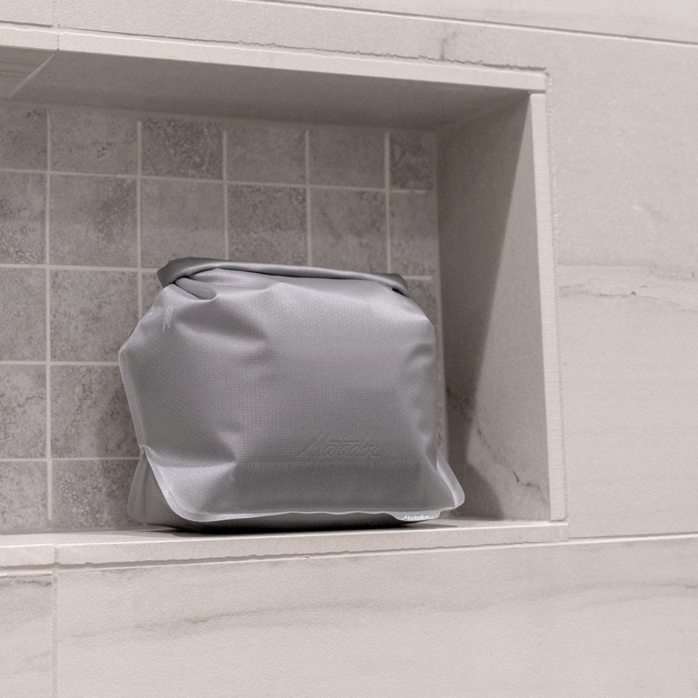 White toiletry case sitting in shower nook