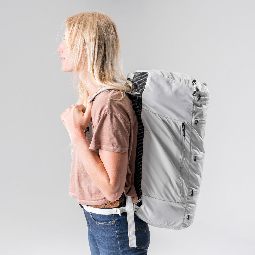 Side view of blonde woman wearing White SEG45 on light gray background