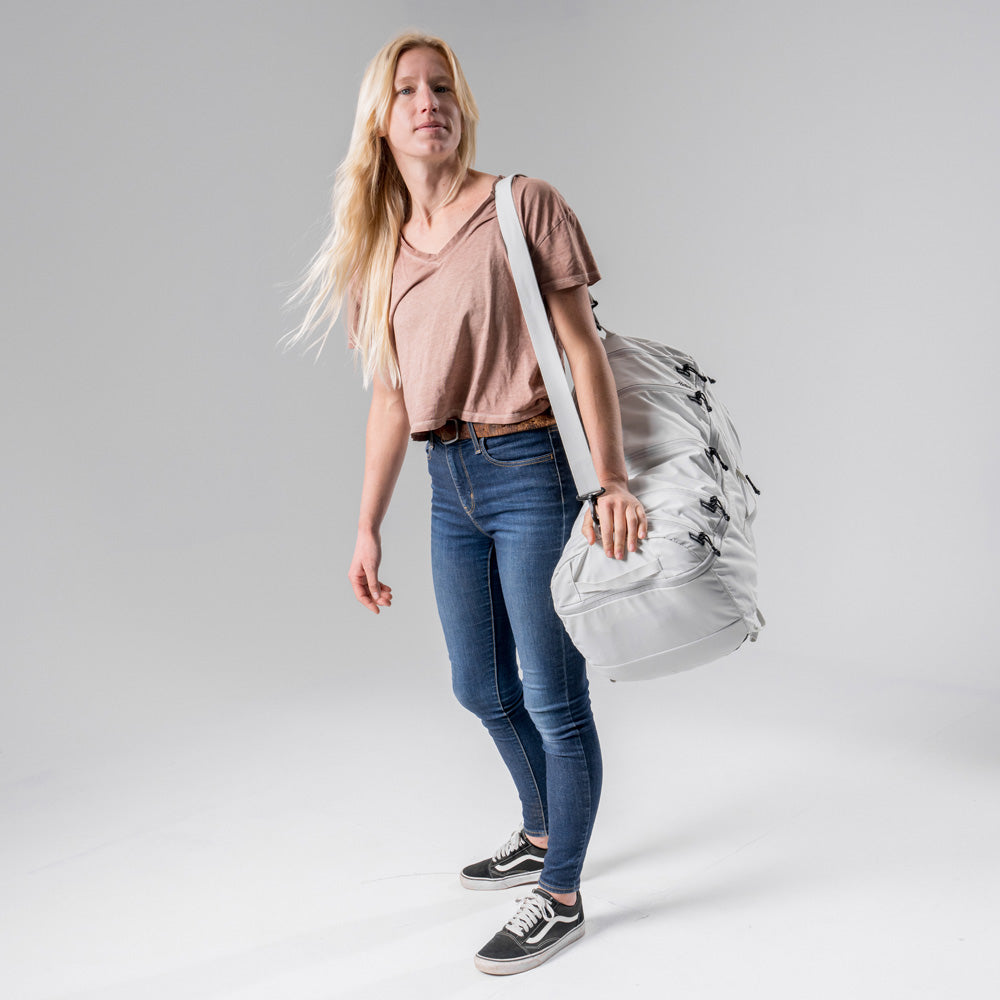 blonde woman on light gray background using White SEG45 as a duffle