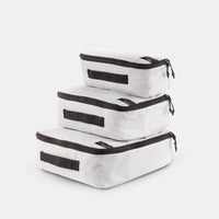 white small, medium and large packing cubes stacked on a light gray background