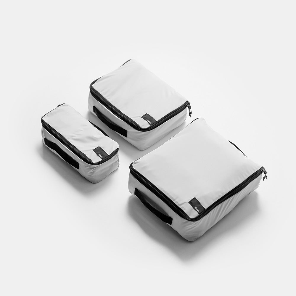 angled top view of white small, medium, and large packing cubes on white background