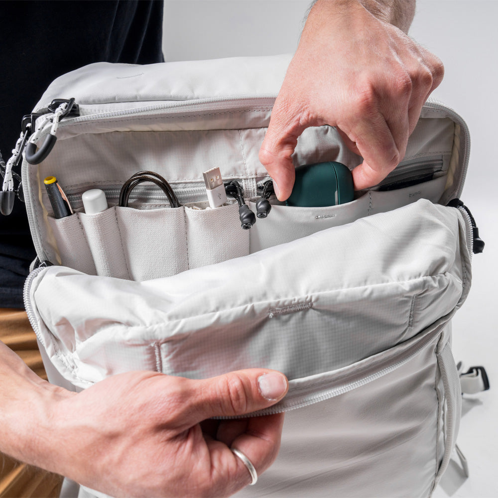 close up view of hands pulling headphone case out of white Globerider45 admin pocket