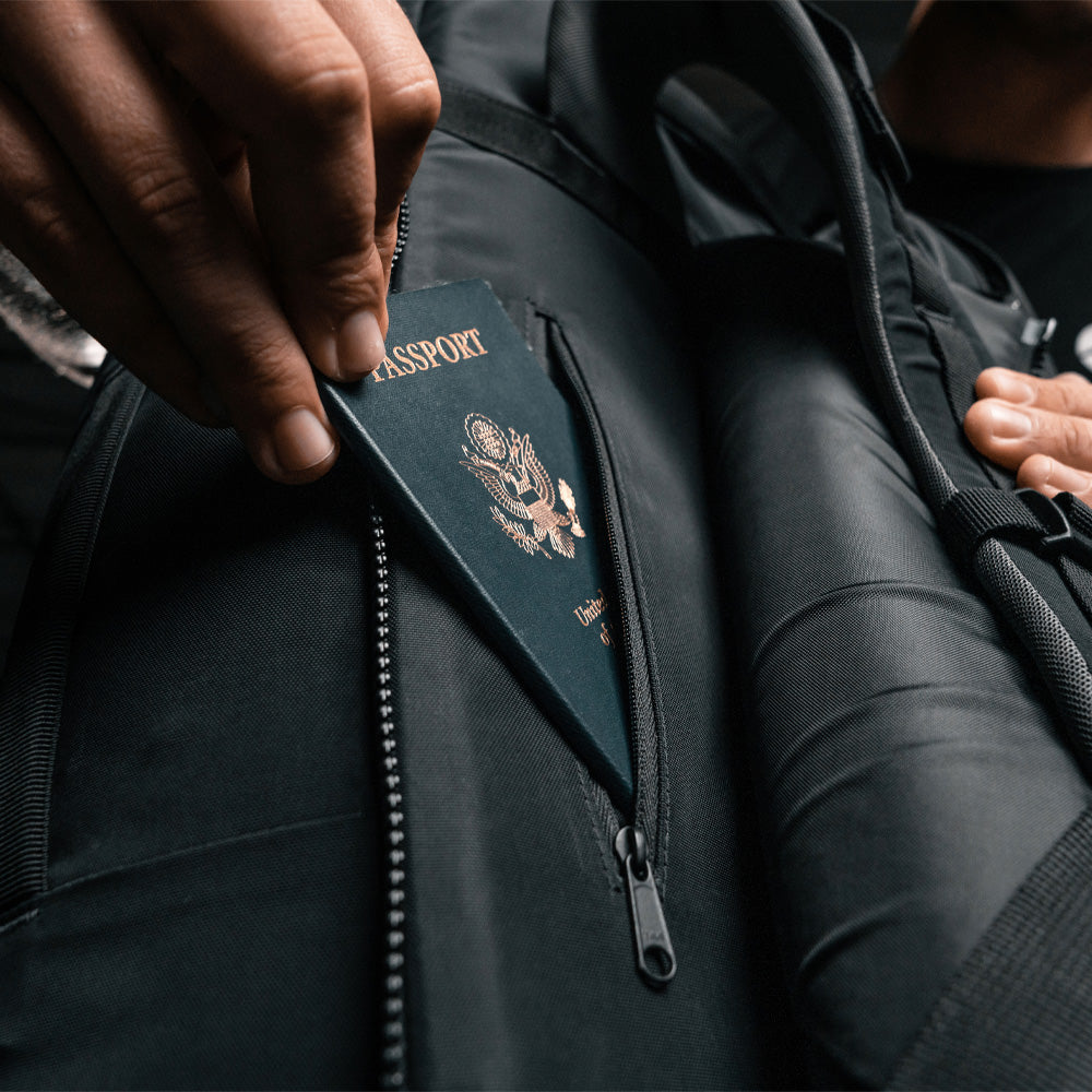 Close up view of a passport being placed in back panel smugglers pocket