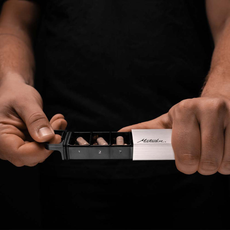 Man opening pill canister on black background