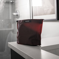 garnet toiletry case sitting on bathroom counter corner