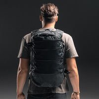 Back view of man wearing SEG28 on dark gray background