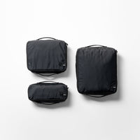 Top view of 3 black packing cubes in small, medium and large against a white background.