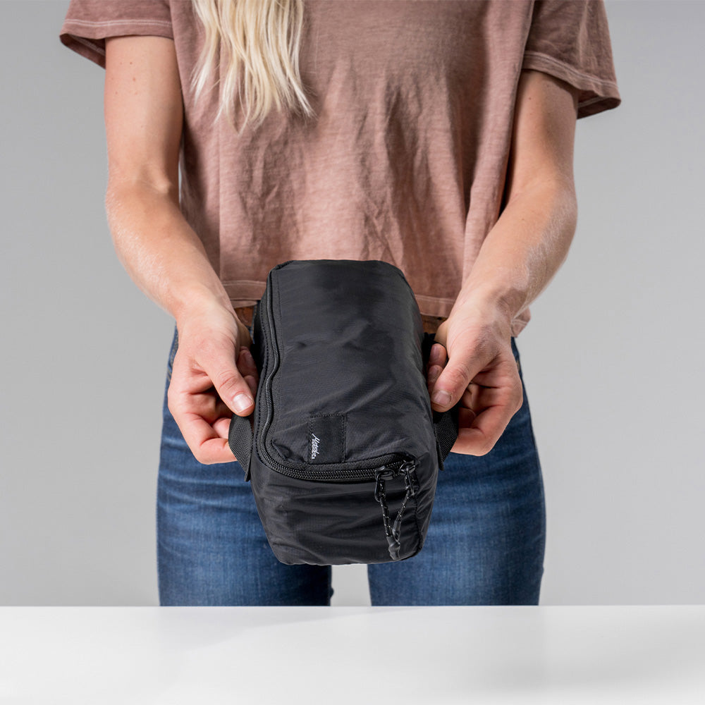 woman holding small black packing cube