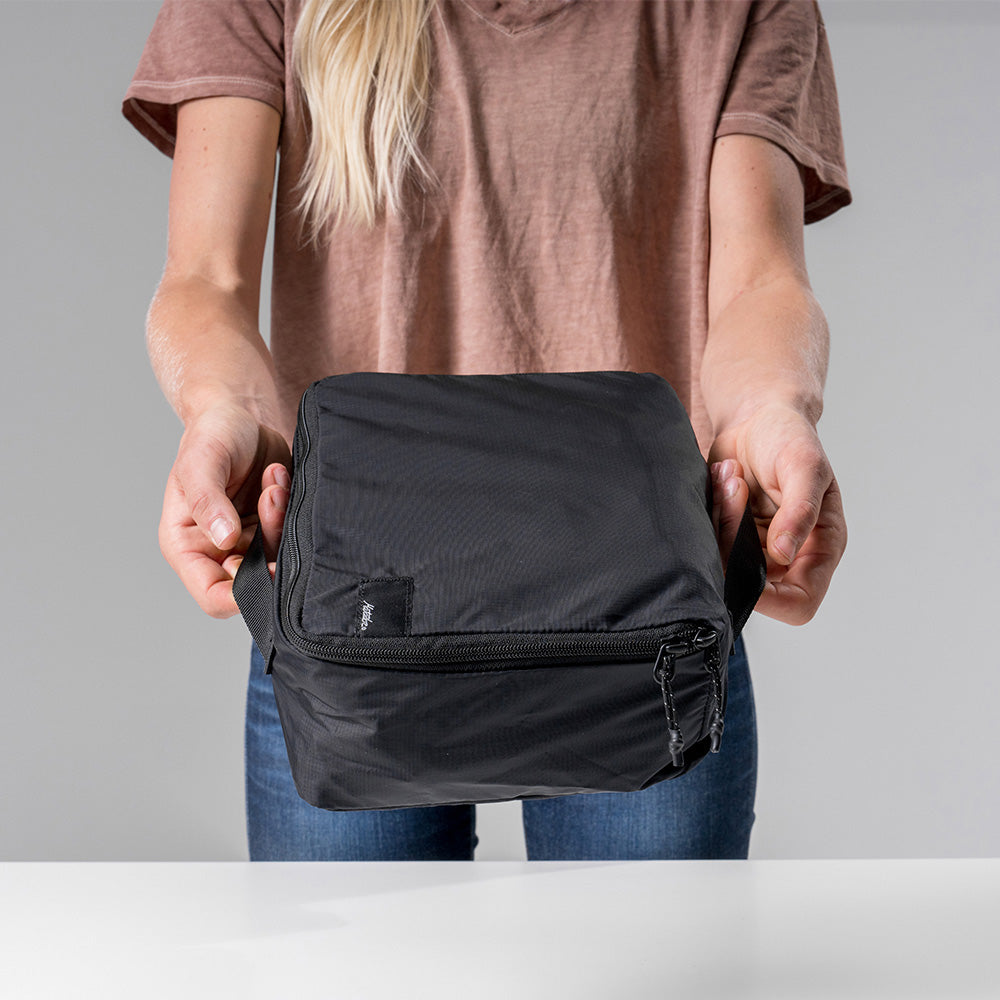 woman holding medium black packing cube