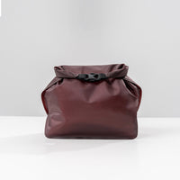 back view of garnet waterproof toiletry case on light gray background