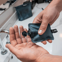 Hands squeezing blue flatpack bottle over sink