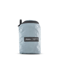 packed up slate blue duffle on white background