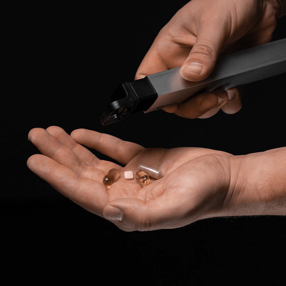 Hand pouring out fish oil pills from pill canister to other hand