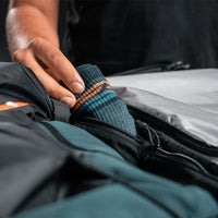 close up view of man placing socks into interior size zipper compartment