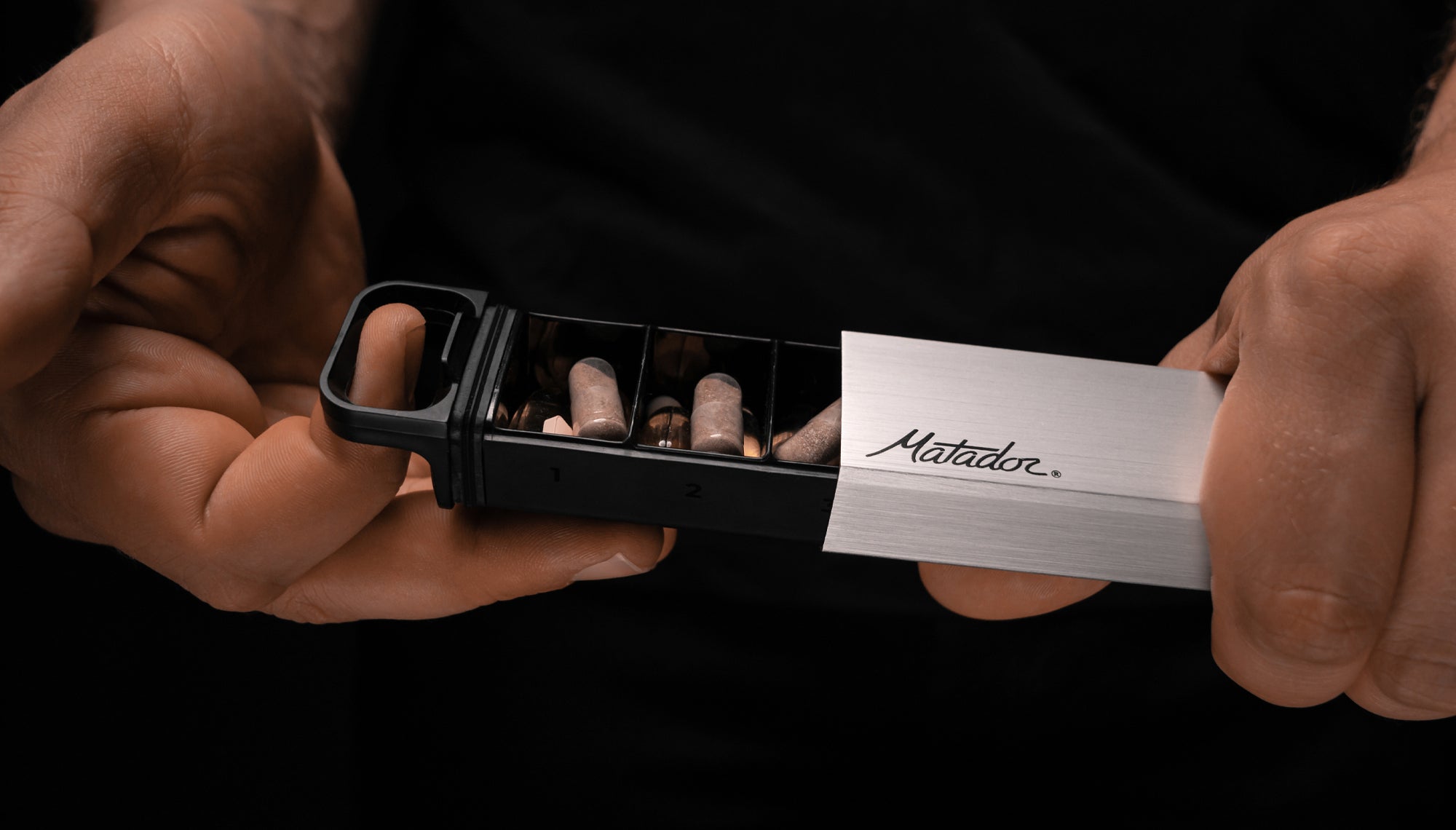 hands pulling open pill canister to show pills inside