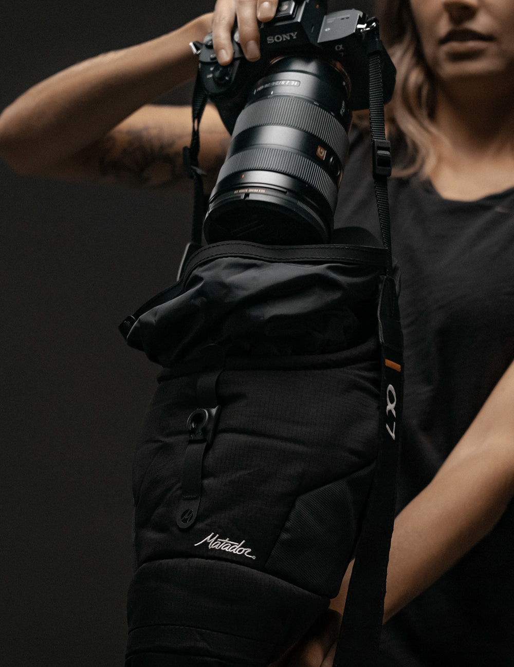 woman pulling camera out of base layer