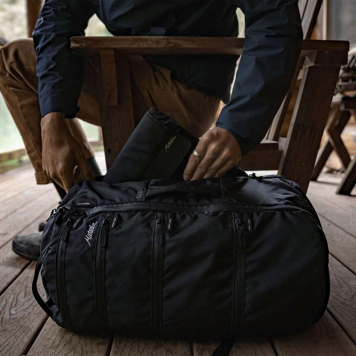 Man outside, pulling Laptop base layer from bag