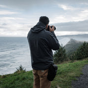 Back view of man taking photos of the ocean