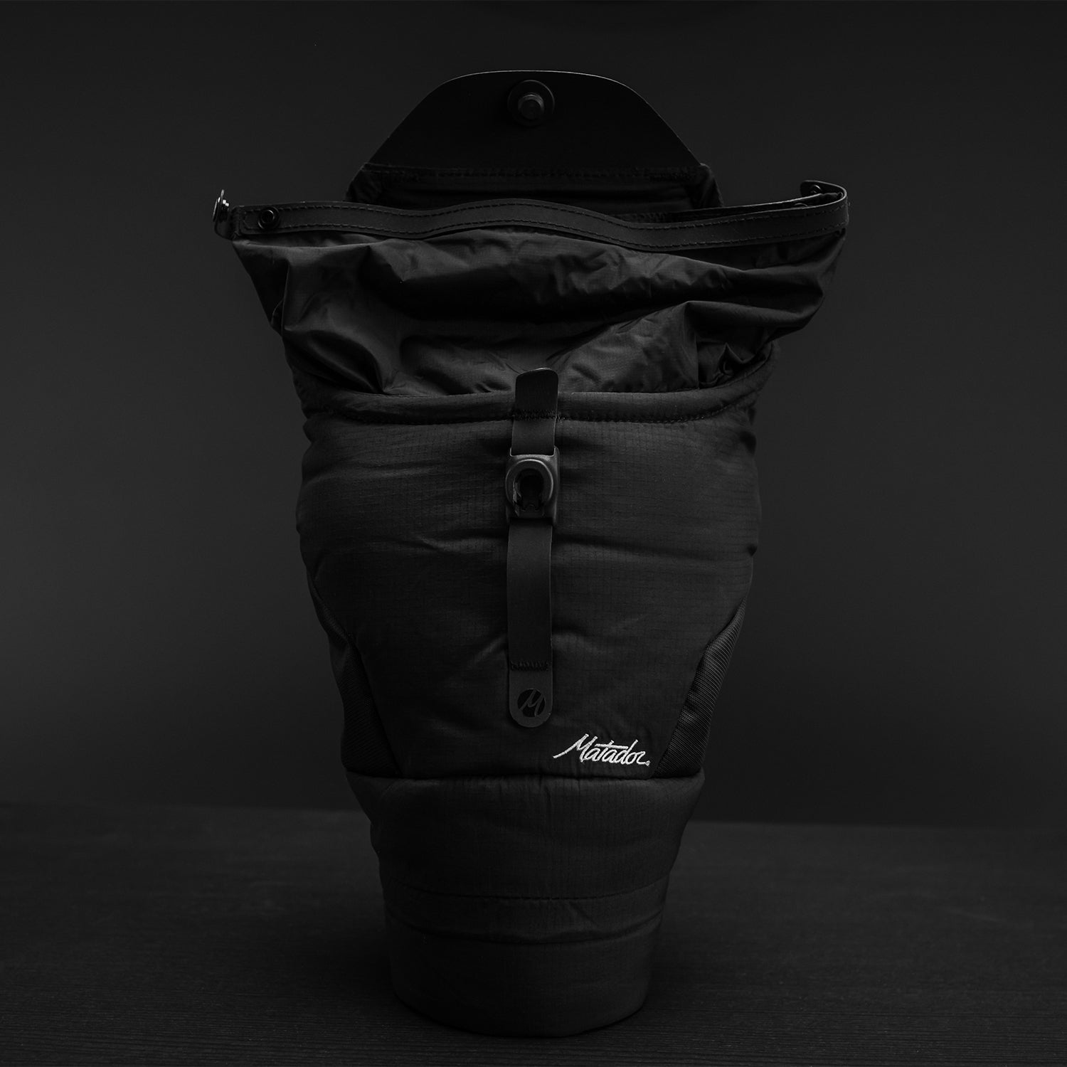 Front view of open topped Camera Base Layer on black background