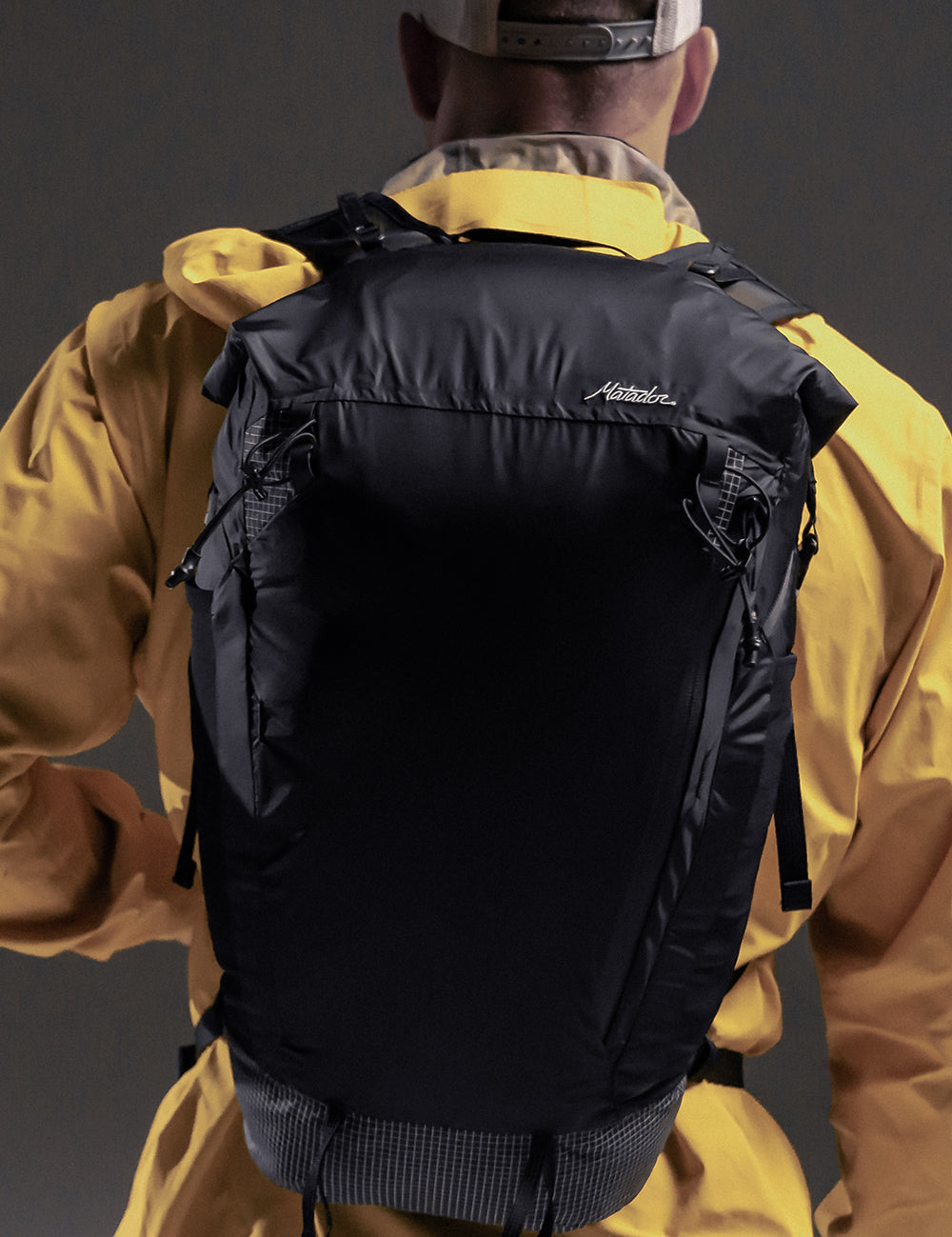 man in yellow jacket wearing black backpack