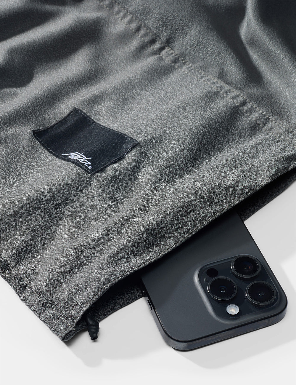 detail view of beach towel zipper pocket with phone.
