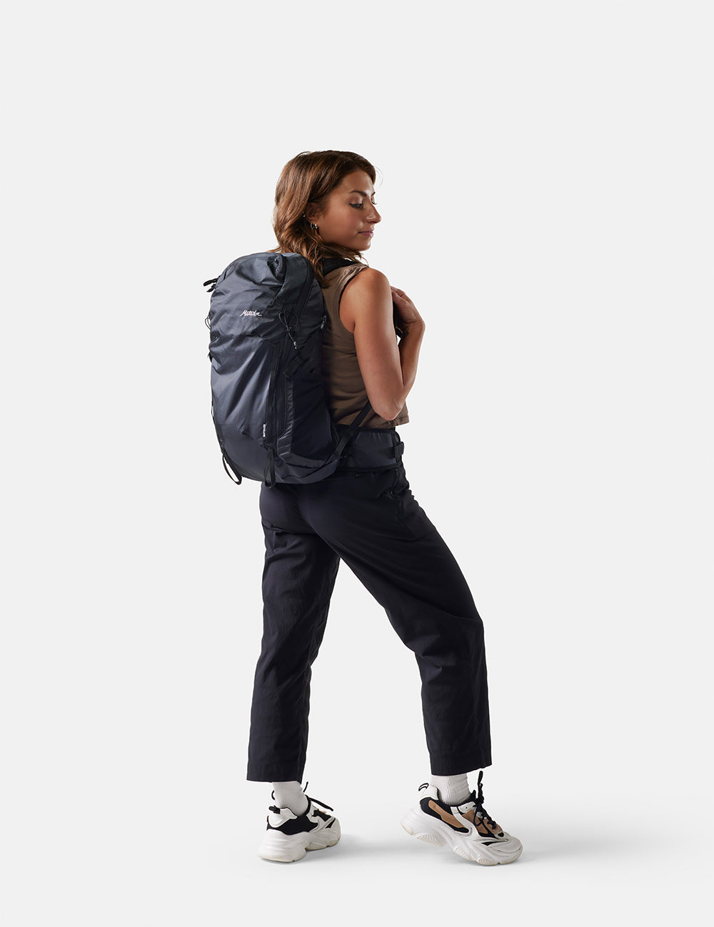 Person wearing a black backpack on a white background