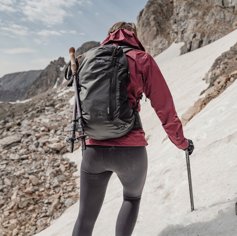 woman on snowy terrain wearing black backpack