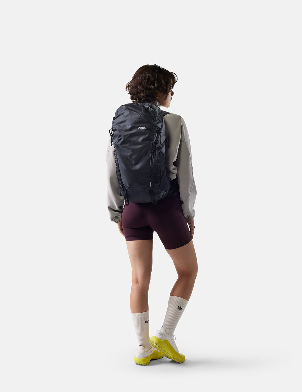 Person wearing a black backpack on a white background