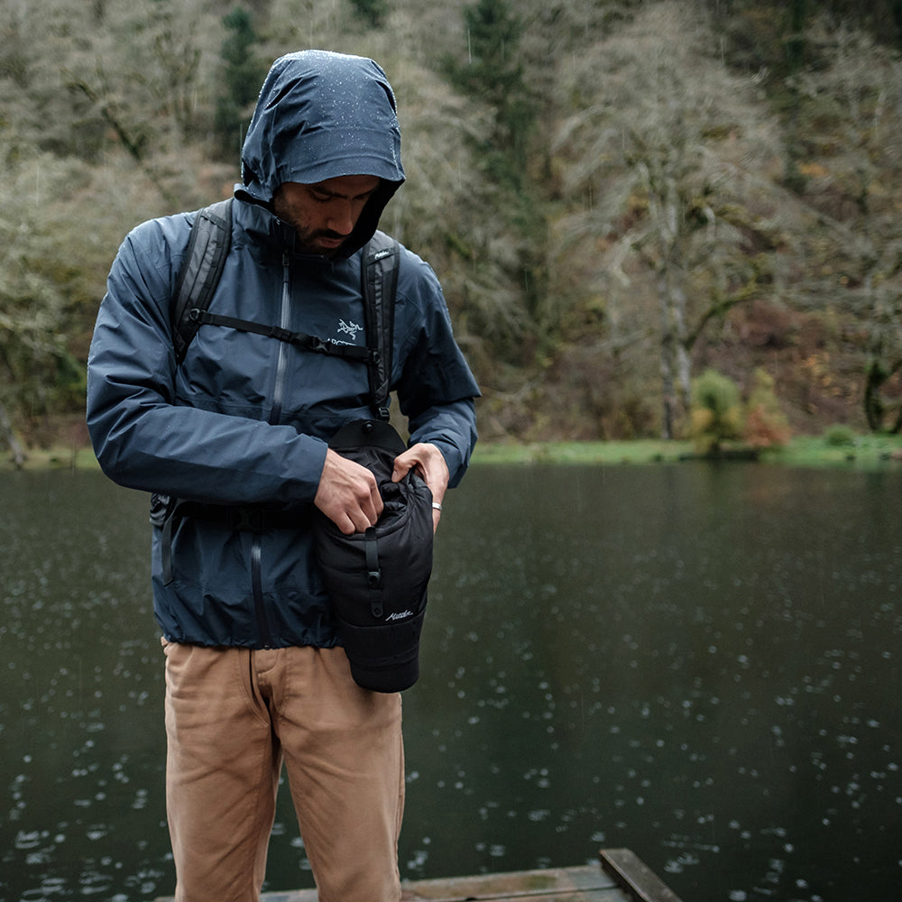 man on rainy dock, reaching for camera in base layer