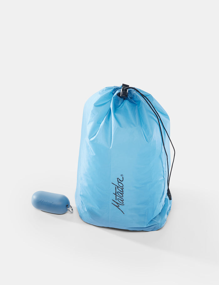 Blue drawstring bag with a small blue item on a white background
