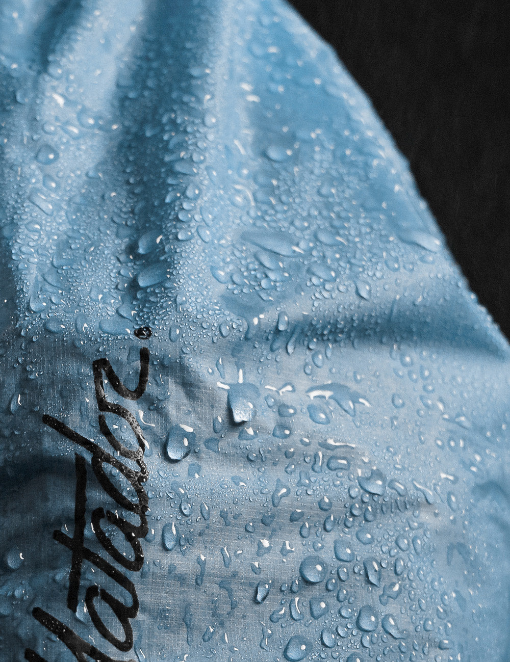 close up view of water beading off blue material