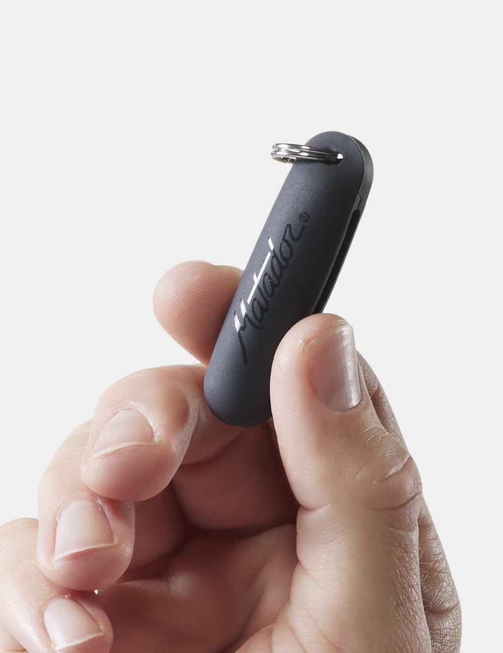 close up of hand holding earplug case with matador logo