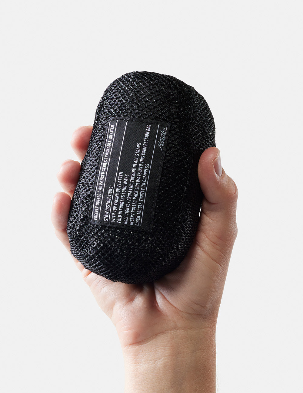 hand holding small packed up duffle