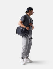 Person holding a duffel bag against a white background