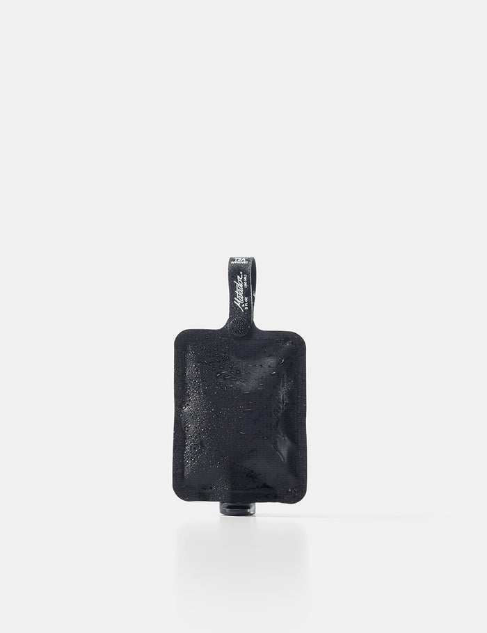 Black toiletry bottle with a strap on a white background