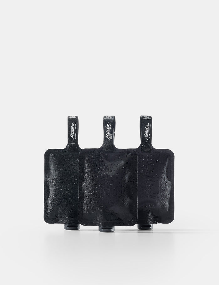 Three black toiletry bottles on a white background