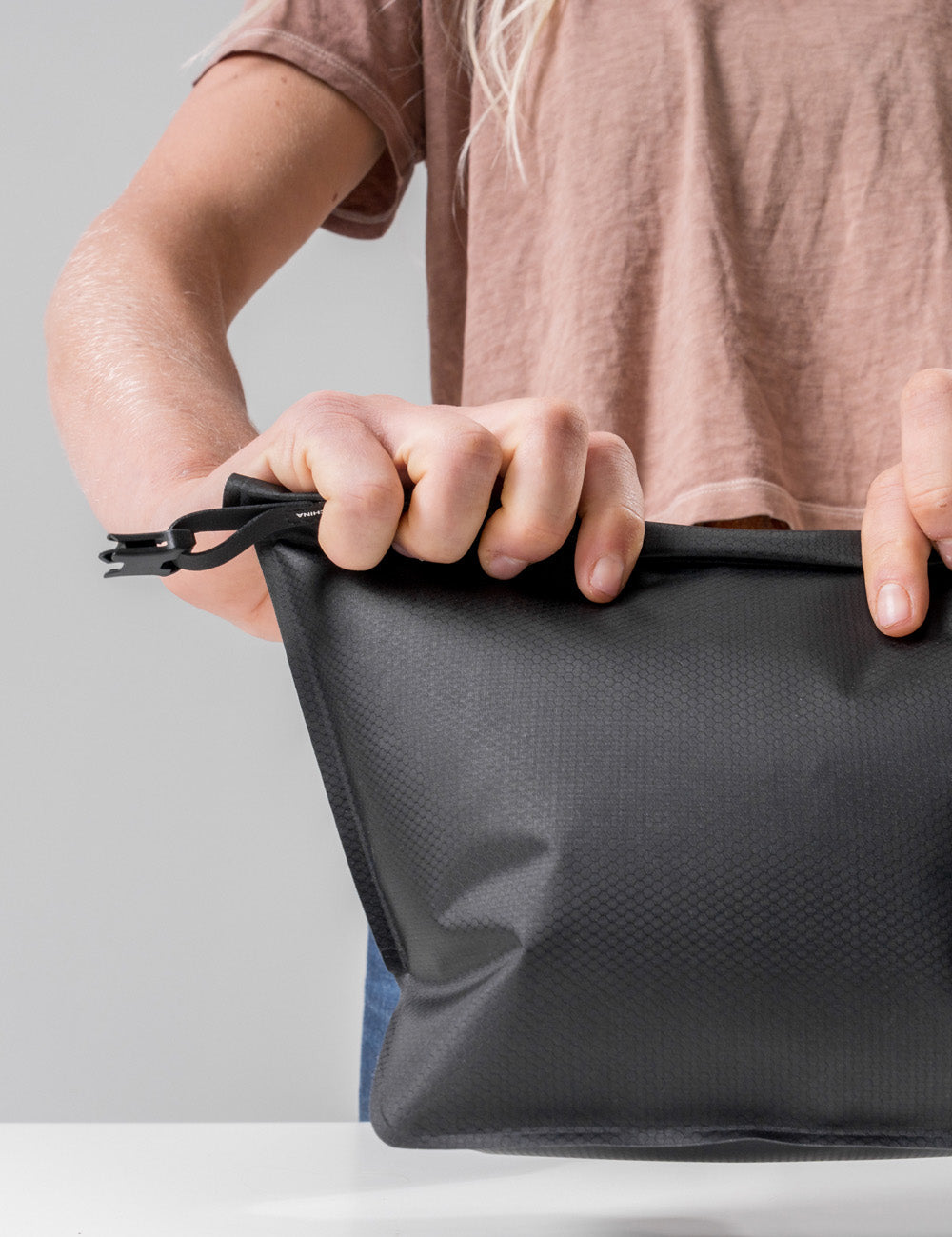 Hands rolling toiletry case closed